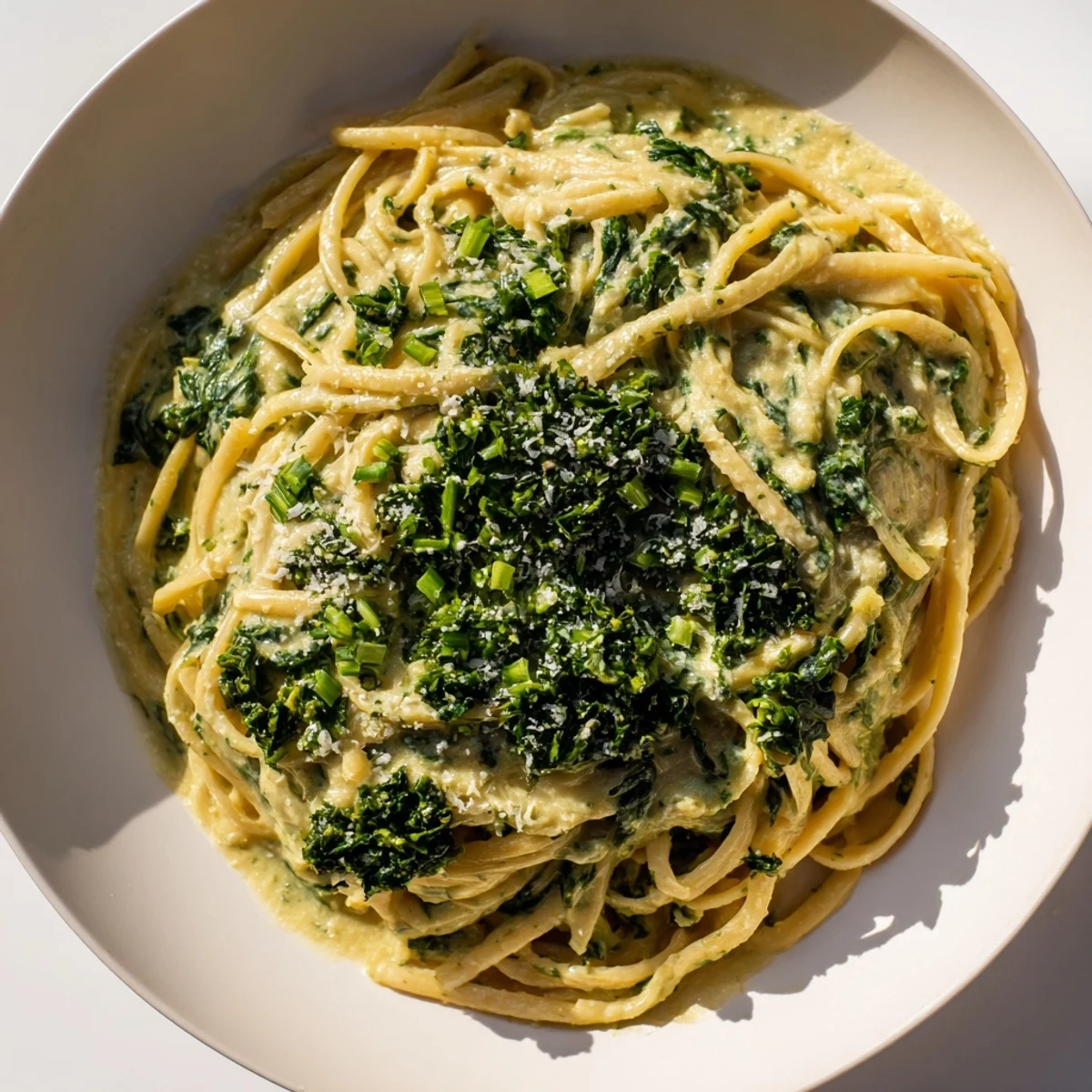 Linguine coated in vibrant green goddess pasta sauce, topped with fresh herbs, a delicious vegetarian meal.