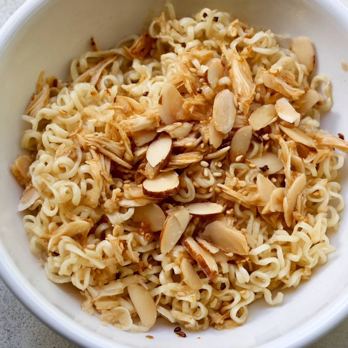 A vibrant bowl of Crunchy Ramen Chicken Salad with shredded cabbage, carrots, and tender rotisserie chicken tossed in a sweet sesame dressing.