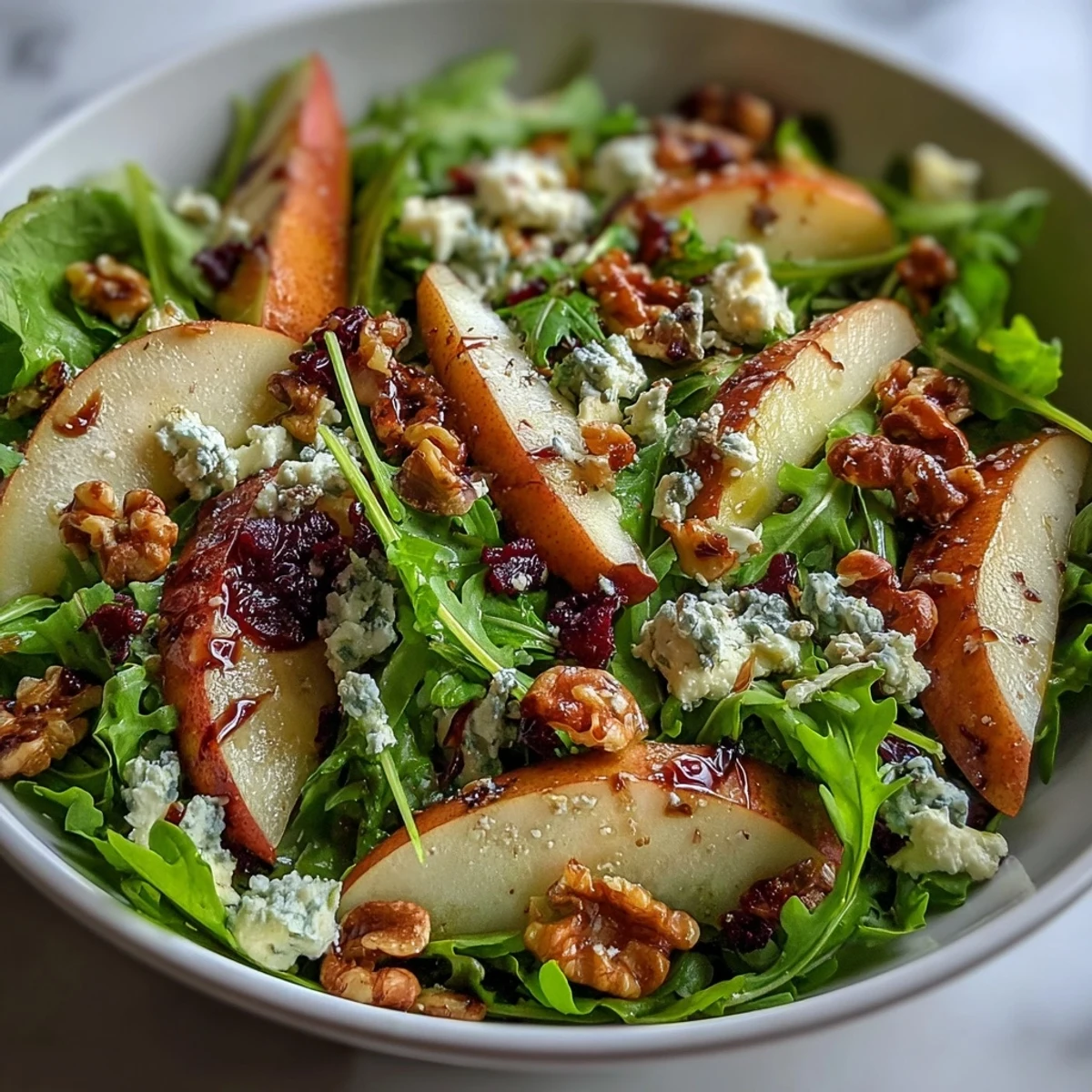 Fresh arugula and sliced pears topped with crumbled blue cheese and toasted walnuts in an Arugula and Pear Bowl.