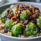Tender roasted Brussels sprouts and onions piled high over hearty grains, topped with crunchy walnuts and dried cranberries for a nourishing vegetarian dinner.