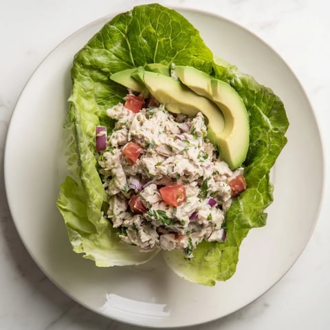 Fresh tuna salad lettuce wraps, creamy and bright, with avocado and juicy tomato, ready to eat.