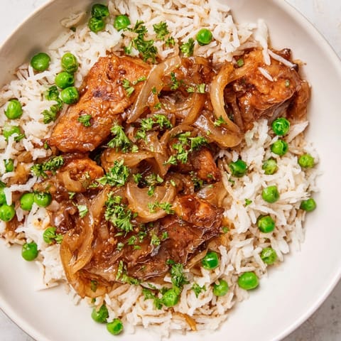 One-Pot Creamy Lemon Chicken and Rice served hot in a skillet, garnished with fresh parsley and lemon zest.