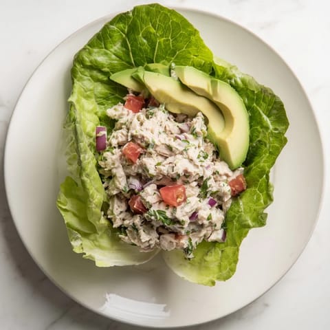 Fresh tuna salad lettuce wraps, creamy and bright, with avocado and juicy tomato, ready to eat.