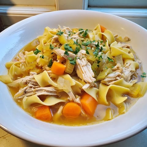 Fragrant Cozy Chicken Noodle Soup, a hearty, homemade American classic, served hot in a mug.