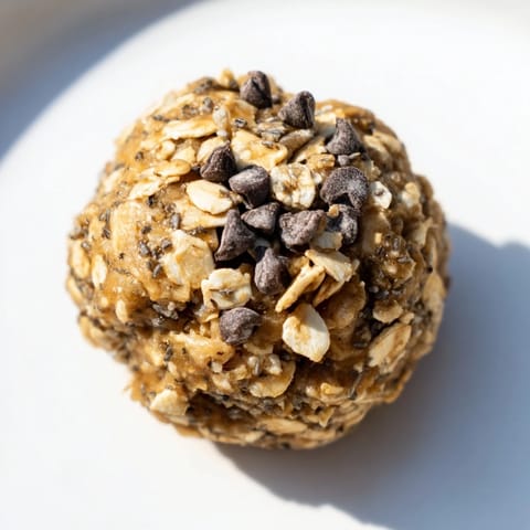 These no-bake peanut butter energy balls show textured oats and peanut butter mixed with sweet drizzle.