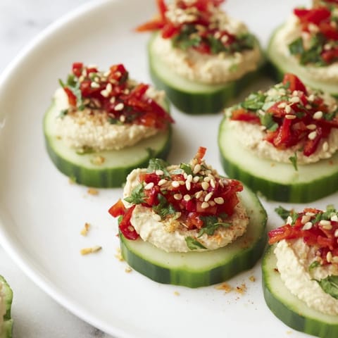 Quick Hummus and Cucumber Bites: cool cucumber rounds topped with creamy hummus, ready to eat.