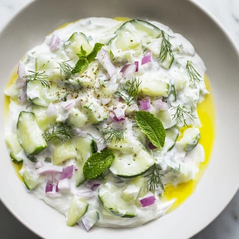 Close-up of a refreshing Cucumber and Greek Yogurt Tzatziki Salad, garnished with fresh dill.