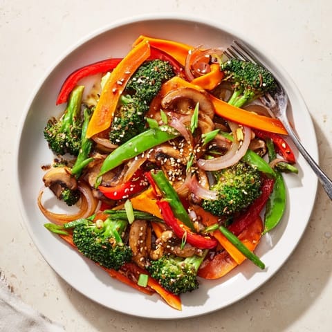 Freshly grated ginger steams from a vibrant mix of crisp broccoli, carrots, and snap peas in this quick Ginger Stir-Fried Vegetables dish.
