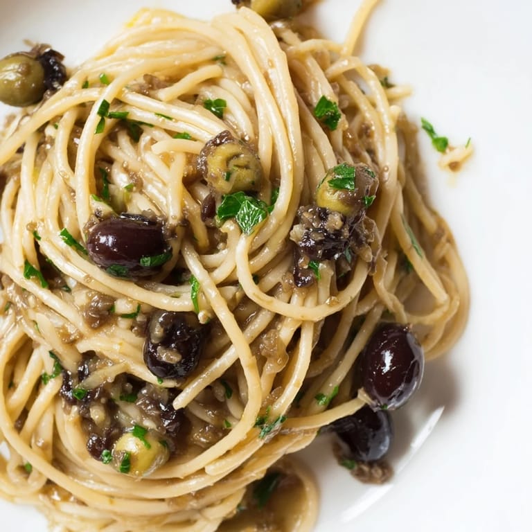 Serving suggestion for Olive Tapenade Pasta, a vegan main dish with a glossy olive oil sauce and rich, aromatic olive and caper blend.
