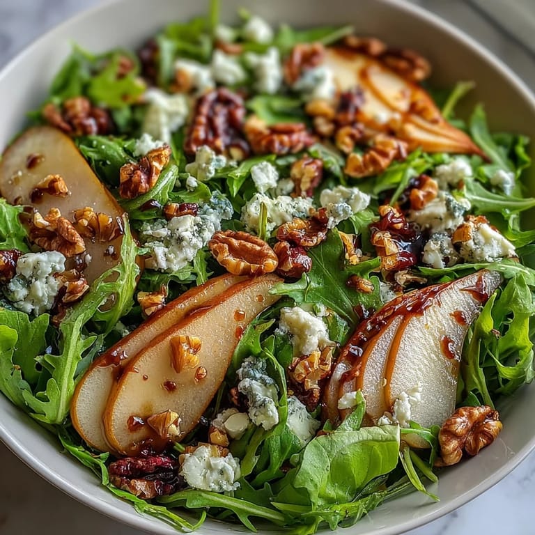 Overhead view of a large Arugula and Pear Bowl tossed with walnuts, sliced pears, and fresh greens, ready to serve.
