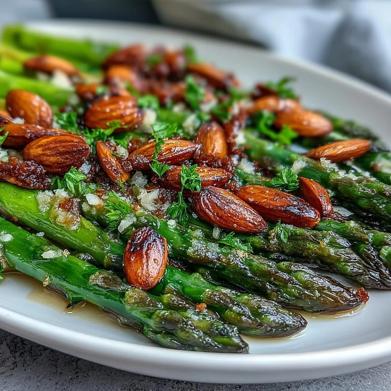 Tender asparagus sautéed in rich lemon butter, garnished with golden almonds for a vibrant, flavorful vegetable side.