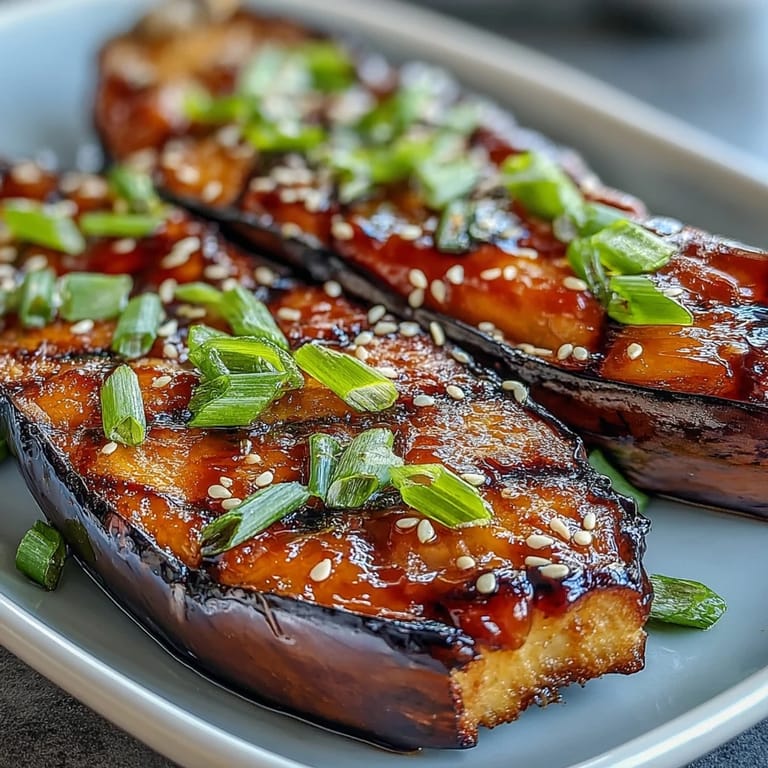 Roasted miso glazed eggplant halves with a glossy, caramelized topping.